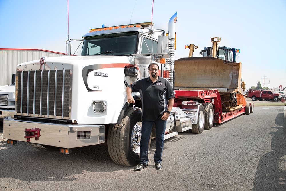Employee standing in front of a truck